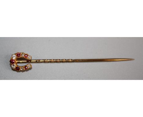 An unmarked gold stick pin of horse shoe form, set with six alternating diamonds and five rubies. Gross weight 3gm, 6.5cm