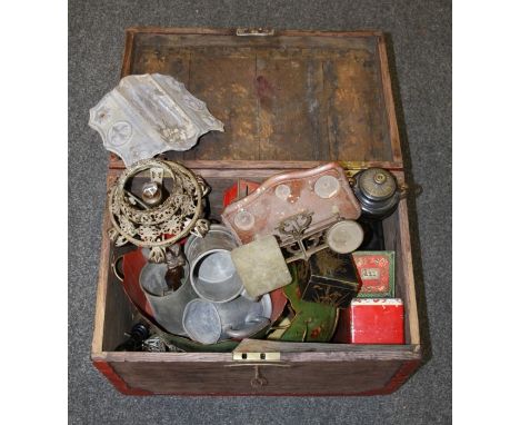 An oak strong box with brass side handles containing various items including hand bell, brass wirework table lamp, black slat