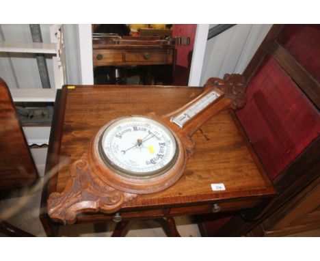 A carved oak aneroid barometer
