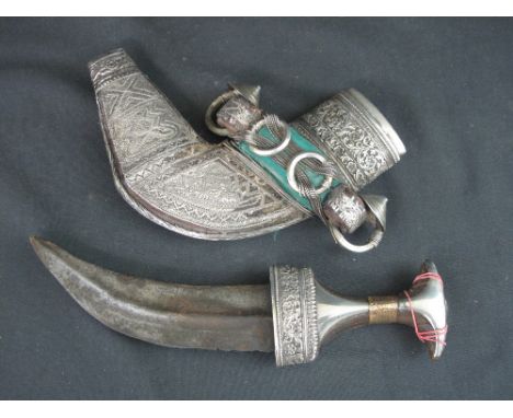 AN OMANI ARAB JABIYA DAGGER, having foliate engraved silver and yellow metal mounted handle, ribbed curved double edged blade