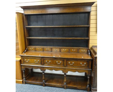 A good twentieth century Welsh dresser, the base with floor level platform having four turned pepper-pot supports and three d