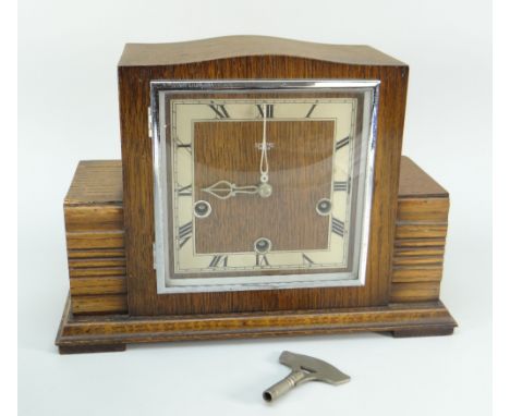 An early to mid twentieth century Art Deco wooden encased mantel clock with square dial bearing Roman numerals and inscribed 