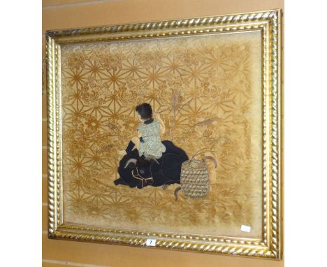 A nineteenth century Chinese silk and fabric panel depiction of a boy playing a flute while resting on an ox in a contemporan