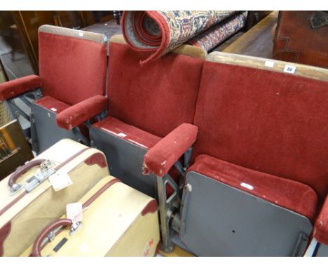 A trio of adjoining vintage numbered red-velvet covered and grey metal folding cinema-seats removed from a South Wales cinema