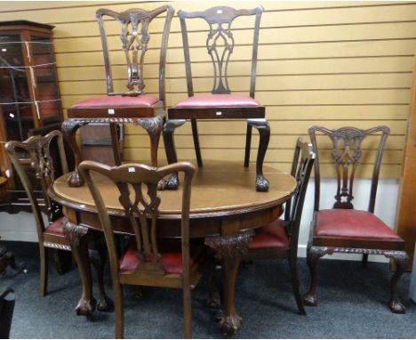 An Edwardian oval extending mahogany dining table on carved ball &amp; claw supports together with three extension leaves and