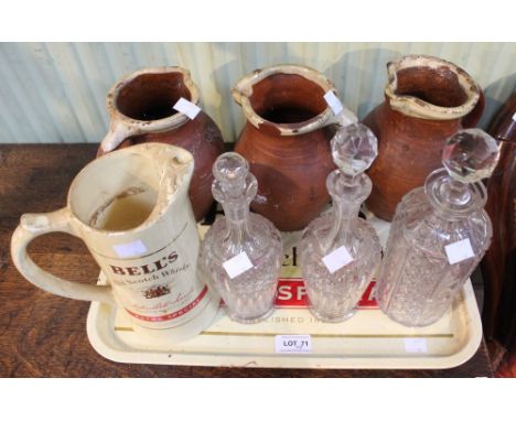 A vintage Bells whisky tin tray with a Bells water jug, three stoneware jugs and three glass decanters&nbsp;