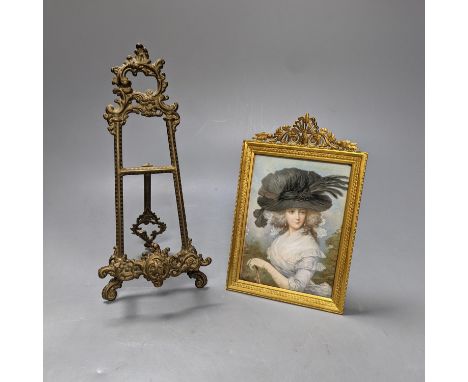 Victorian miniature print of a lady in a black feather hat,  in gilt-brass frame, and a small brass easel, easel 25 cms high.