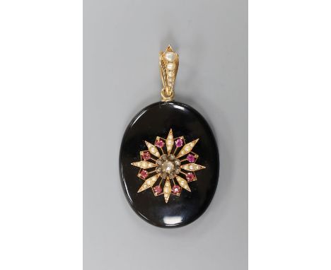 A Victorian black enamel, rose cut diamond, ruby coloured paste and seed pearl set oval mourning pendant, with glazed back an