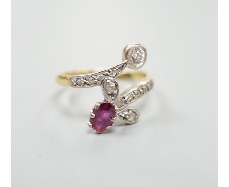 An early to mid 20th century 18ct, ruby and diamond set crossover ring, with diamond set shoulders, size Q/R, gross 4.7 grams