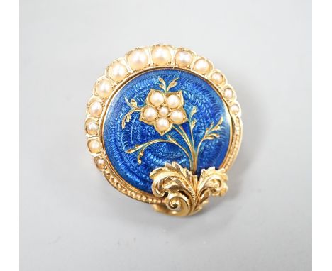 A nearly 20th century yellow metal, blue enamel and seed pearl set circular brooch, 22mm, gross 4.5 grams, in fitted box.