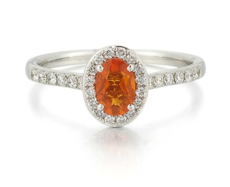 AN 18 CARAT WHITE GOLD FIRE OPAL AND DIAMOND CLUSTER RING an oval-cut fire opal within a border of round brilliant-cut diamon