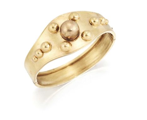 A LATE 19TH CENTURY HINGE OPENING BANGLE the tapering front with applied beaded decoration, to a plain hinge opening back. 5.