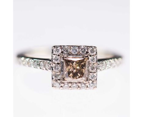 AN 18 CARAT WHITE GOLD FANCY-COLOURED DIAMOND CLUSTER RING a fancy light brown princess-cut diamond within a square border of