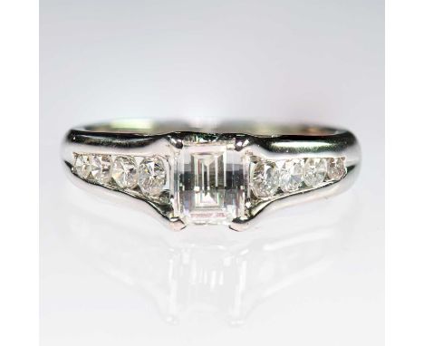 A DIAMOND RING a modified octagonal-cut diamond to tapering shoulders channel-set with round brilliant-cut diamonds. Estimate