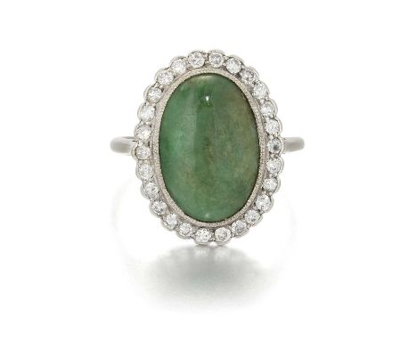 AN EARLY 20TH CENTURY JADE AND DIAMOND CLUSTER RING an oval jade within a milgrain border of old-cut diamonds. Estimated tota