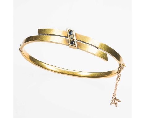 A LATE VICTORIAN 9 CARAT GOLD SAPPHIRE AND DIAMOND HINGE OPENING BANGLE a crossover bangle tied by a sapphire and old-cut dia