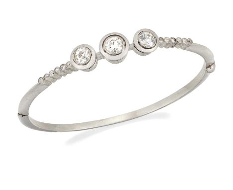 A DIAMOND HINGE OPENING BANGLE three graduated transitional round brilliant-cut diamonds in milgrain settings and halo frames