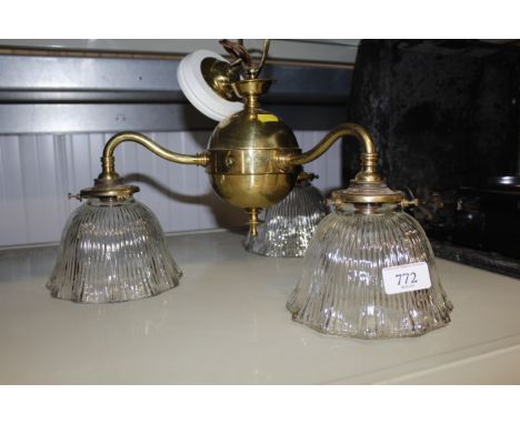 A brass three branch ceiling light with glass shades