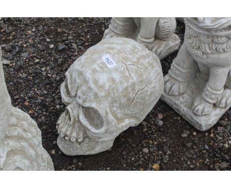 A concrete garden ornament in the form of a skull