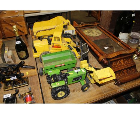 A collection of Tonka toys including dump truck, diggers and a tractor with trailer