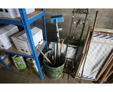 A galvanised dustbin with various gardening tools, walking sticks etc