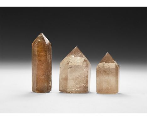 A group of three finely cut and polished smoke quartz crystals, each with hair-like needles of rutile scattered throughout; i