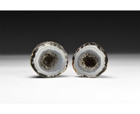 A pair of finely cut and polished mini geodes of banded agate and liliac amethyst crystals to the centre; in white card tray 