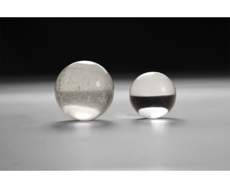 A group of two polished quartz spheres, one with internal 'cut'; in white card tray.  54 grams, 23-28mm (1"). From a historic