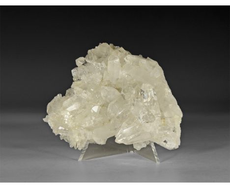 A fine formation of multiple transparent quartz crystals on a flat matrix, in white card tray with label reading: 'Quartz, Co