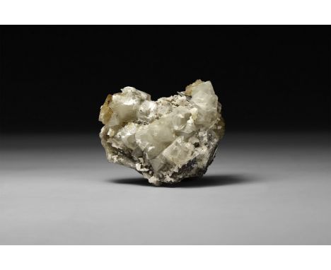 A fine specimen of a dark yellow cubic fluorite crystals, in white card tray with label reading: 'Fluorite, Muscona mine, Sol