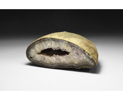 A large cut geode half with large cavity filled with white and pale purple crystals.  1.7 kg, 16.5cm (6 1/2"). From a histori