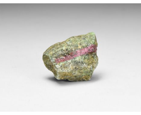 A fine specimen of deep pink ruby in a zoisite mineral specimen, in white card tray with label reading: 'Ruby in Zoisite, Tan