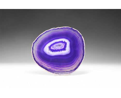 A fine cut and polished agate slice with brown and purple bands, and honeycomb crystal formation, colour enhanced.  453 grams
