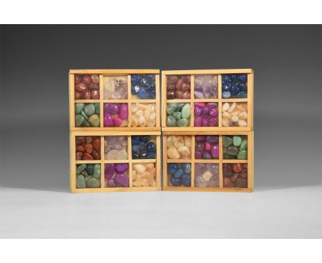 A group of four wooden display boxes, each containing a selection of six different polished crystal specimens, between four a
