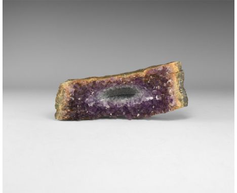 A rectangular matrix with dark purple amethyst crystals to one side with polished 'bowl' section to the centre.  924 grams, 2