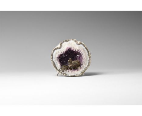 An agate geode filled with purple amethyst crystals with accessory brown calcite.  308 grams, 85mm (3 1/4"). From a historic 