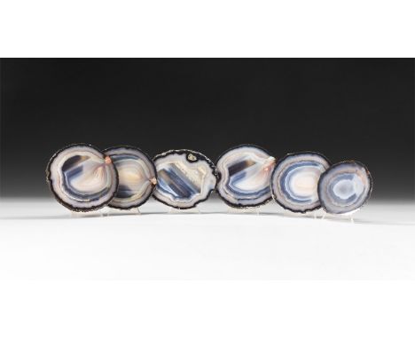 A group of six cut and polished blue banded agate slices, each with fabric to the underside.  905 grams, 10-13.5cm (4 - 5 1/4