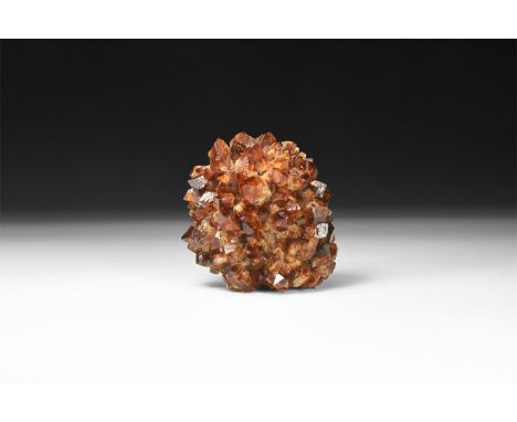 A citrine 'porcupine' of dense small crystals, some with dark brown tips, in white card tray.  271 grams, 80mm (3 1/4"). From