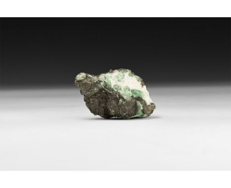 A fine specimen of several pale green emerald crystals on a matrix, in white card tray with label reading: 'Emerald, Minas Ge