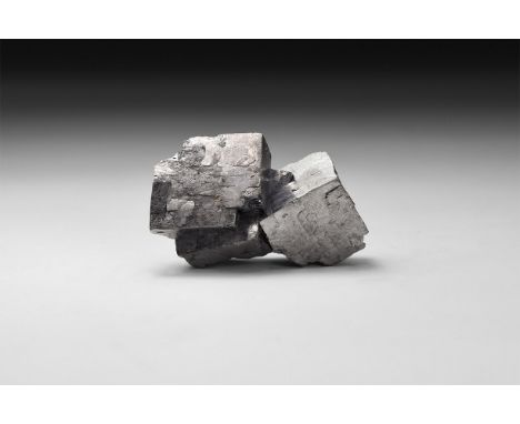 A piece of galena with interlocking and stepped cube-shaped crystals, in white card tray with label reading: 'Galena, Tri-Sta
