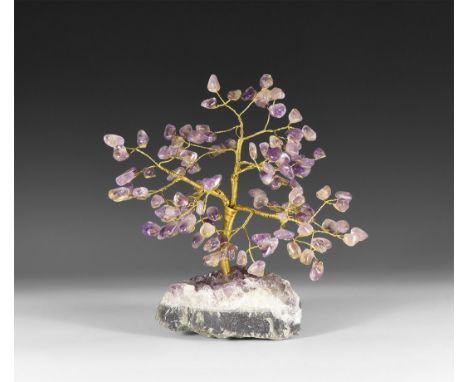 A medium size gemstone tree consisting of a brass trunk and branches tipped with polished amethysts, mounted on a section of 