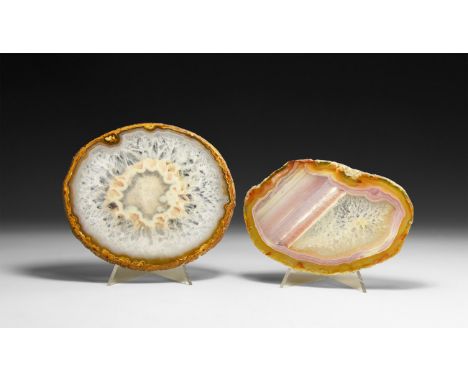 A group of two cut and polished agate slices with orange bands and honeycomb crystals, one also with purple and white bands. 