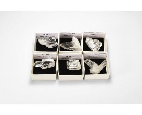A group of six quartz crystal specimens with rainbow reflection, each in a white card tray with label reading: 'Quartz, Minas