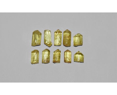 A group of ten pale yellow apatite crystals with 'rainbow' reflection, in a white card box with label reading: 'APATITE, Dura