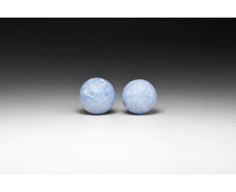 A pair of two cut and polished pale blue calcite spheres in white card tray with label reading Blue Calcite, Mexico.  101 gra