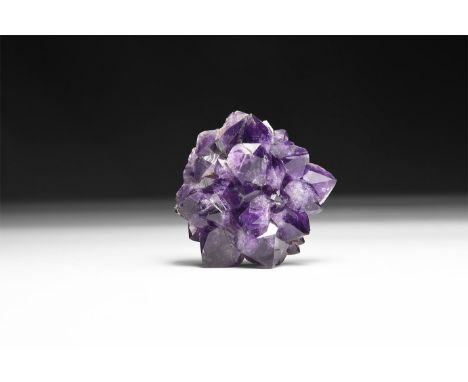 A fine specimen of deep purple amethyst crystals formation, in white card tray with label reading: 'Amethyst Porcupine, Rio G