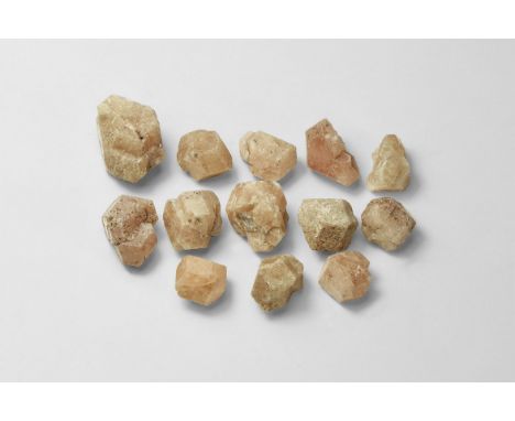 A group of thirteen polyhedral grosular garnet crystals in a card tray.  432 grams total, 10-21mm (1/2 - 3/4"). From a histor