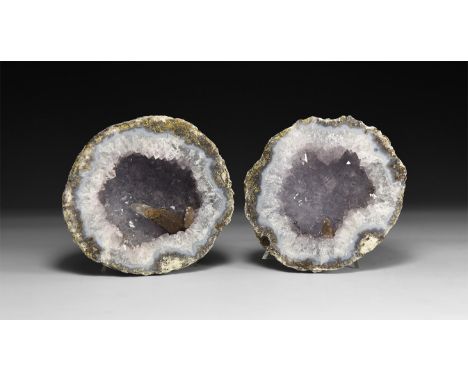 A pair of geodes halves, each with pale amethyst crystals to the void.  960 grams total, 10cm (4"). From a historic ‘Victoria