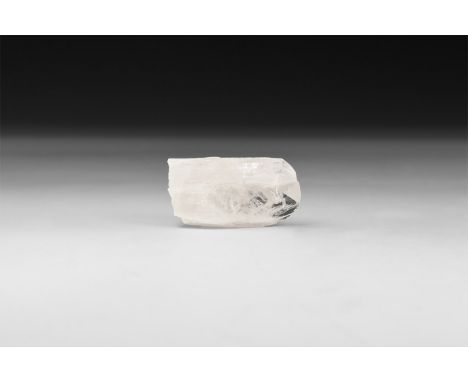 A slightly orange danburite crystal in white card tray with label reading: 'DANBURITE, Charcas, San Luis Potosi, Mexico'.  51