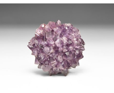 A fine, knob-shaped 'porcupine' of amethyst crystals, in white card tray with label reading: 'Amethyst porcupine, Rio Grande 